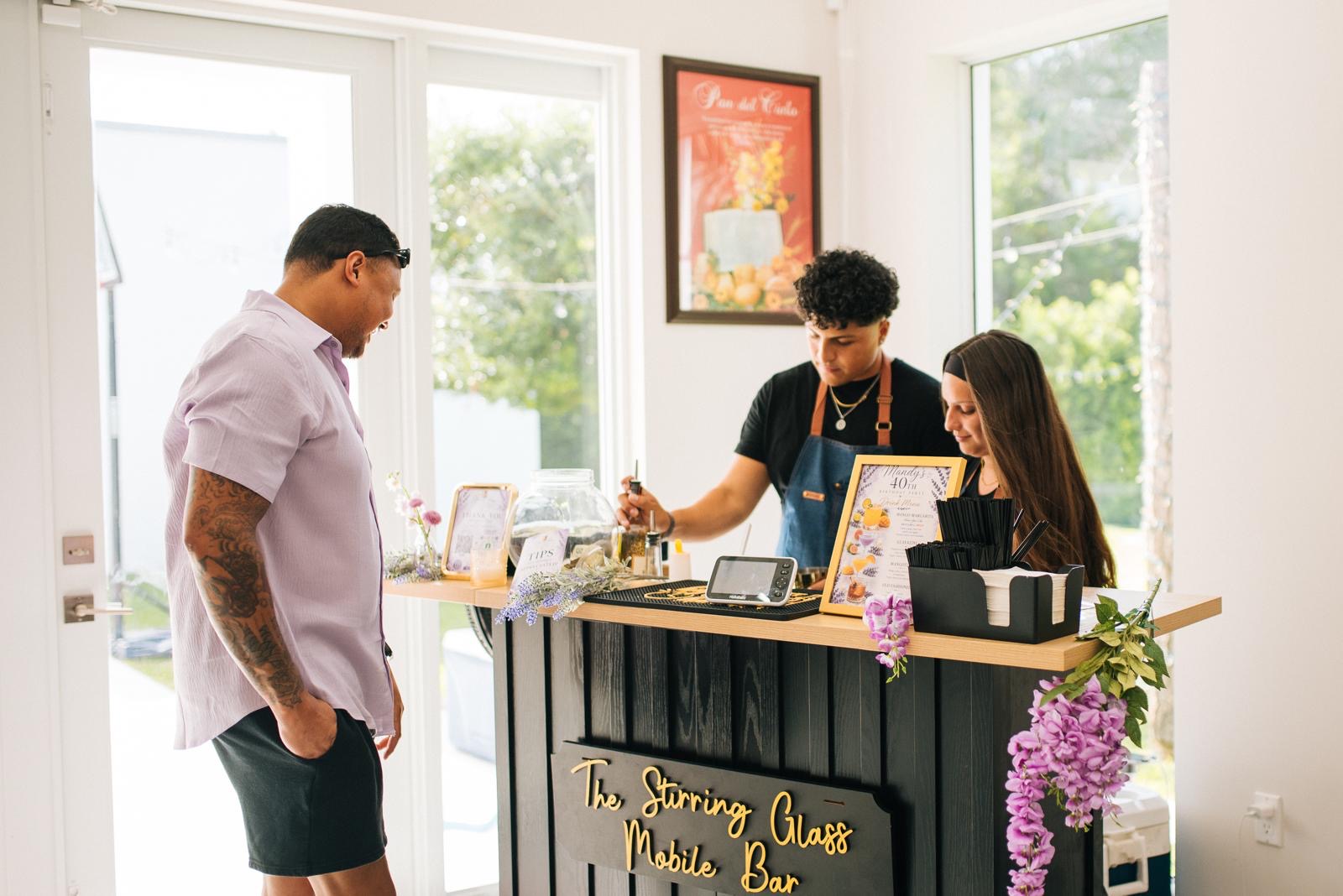 Bartenders serving a guest at the bar
