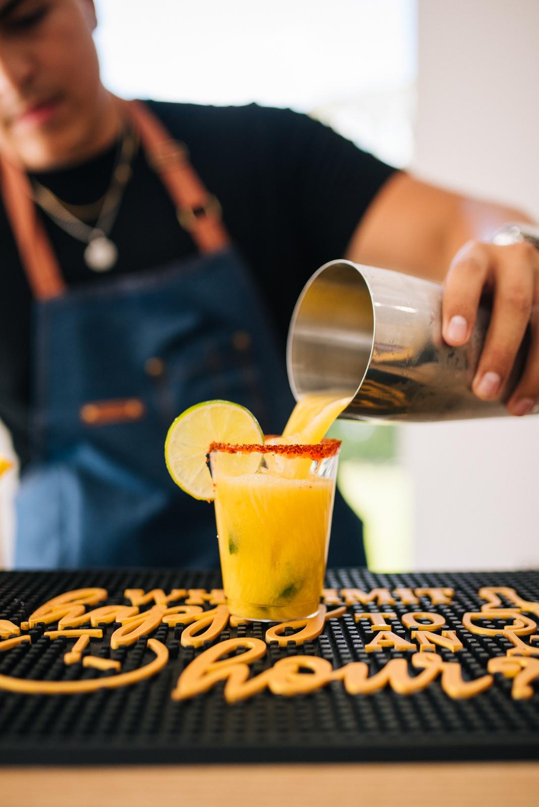 Bartender pouring a mango cocktail